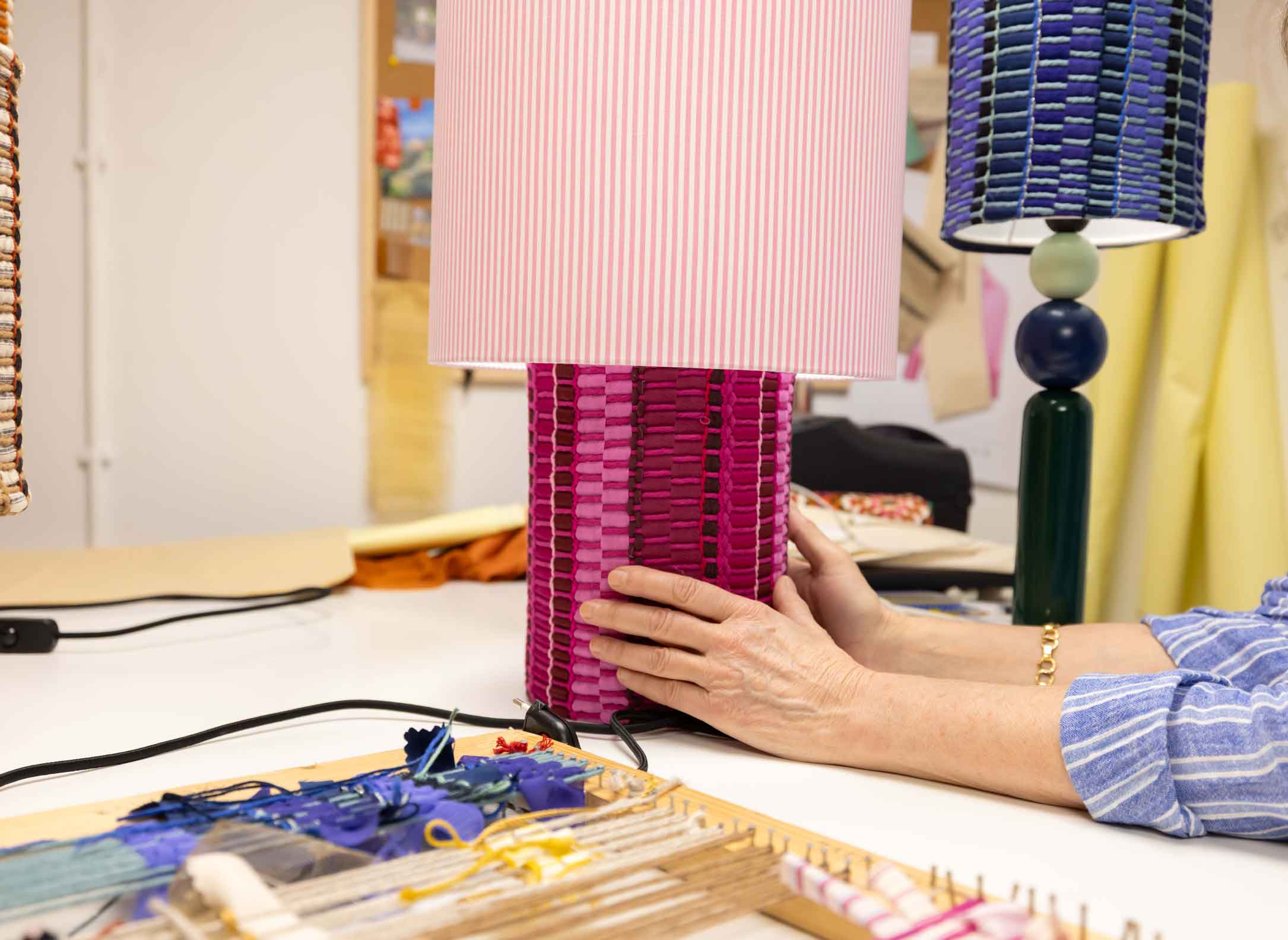 La lámpara N05 es una explosión de color. Perfecta para dar un toque de diversión y diseño a cualquier espacio. Con una base cubierta de tejido hecho en telar, combinando sedas, linos y diferentes texturas y una maxi pantalla de tejido de oxford de rayas rosas.