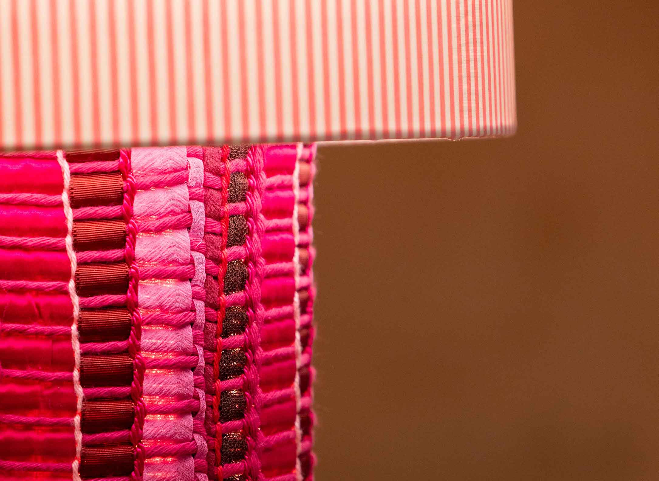 La lámpara N05 es una explosión de color. Perfecta para dar un toque de diversión y diseño a cualquier espacio. Con una base cubierta de tejido hecho en telar, combinando sedas, linos y diferentes texturas y una maxi pantalla de tejido de oxford de rayas rosas.