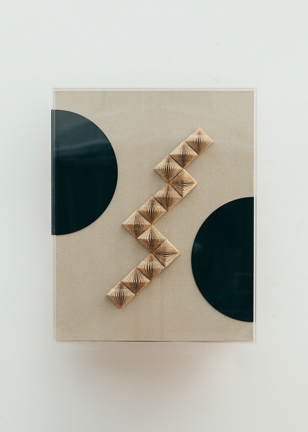 Escultura de pared forrada en lino rústico con caja de metacrilato transparente. Está formada por una serie de libros plegados y formas geométricas en metacrilato.