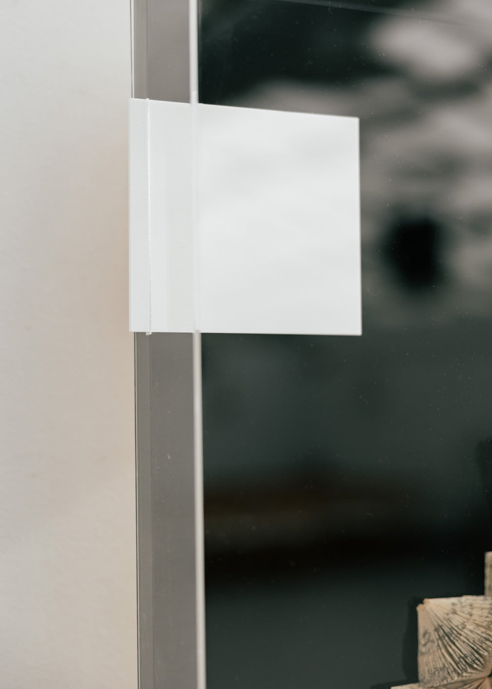 Escultura de pared forrada en metacrilato negro y blanco con caja de metacrilato transparente y serie de libros plegados.