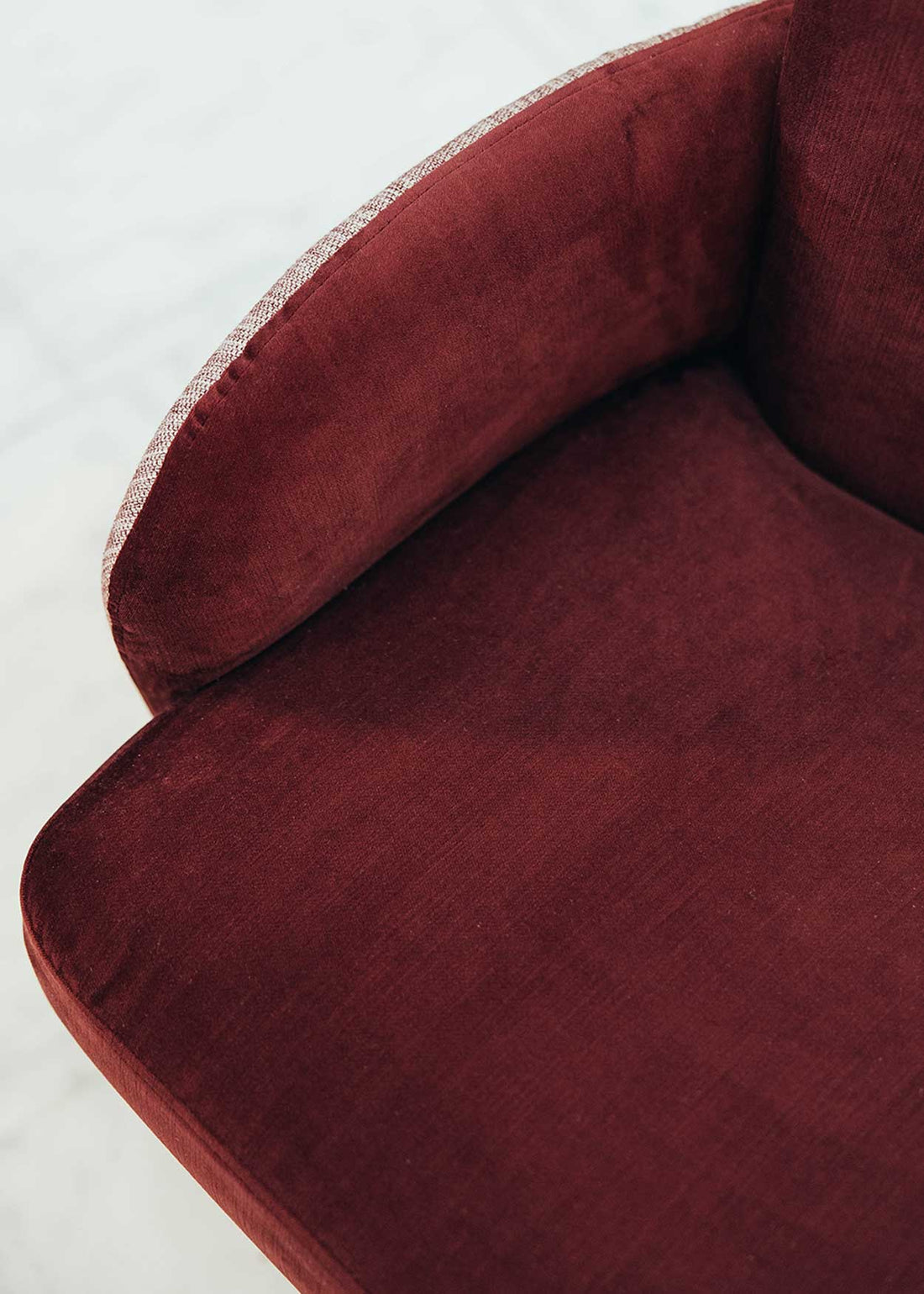 Butaca con estructura de madera tapizada en dos telas, un terciopelo color caldero y una tela jaspeada en tonos beige y caldero.