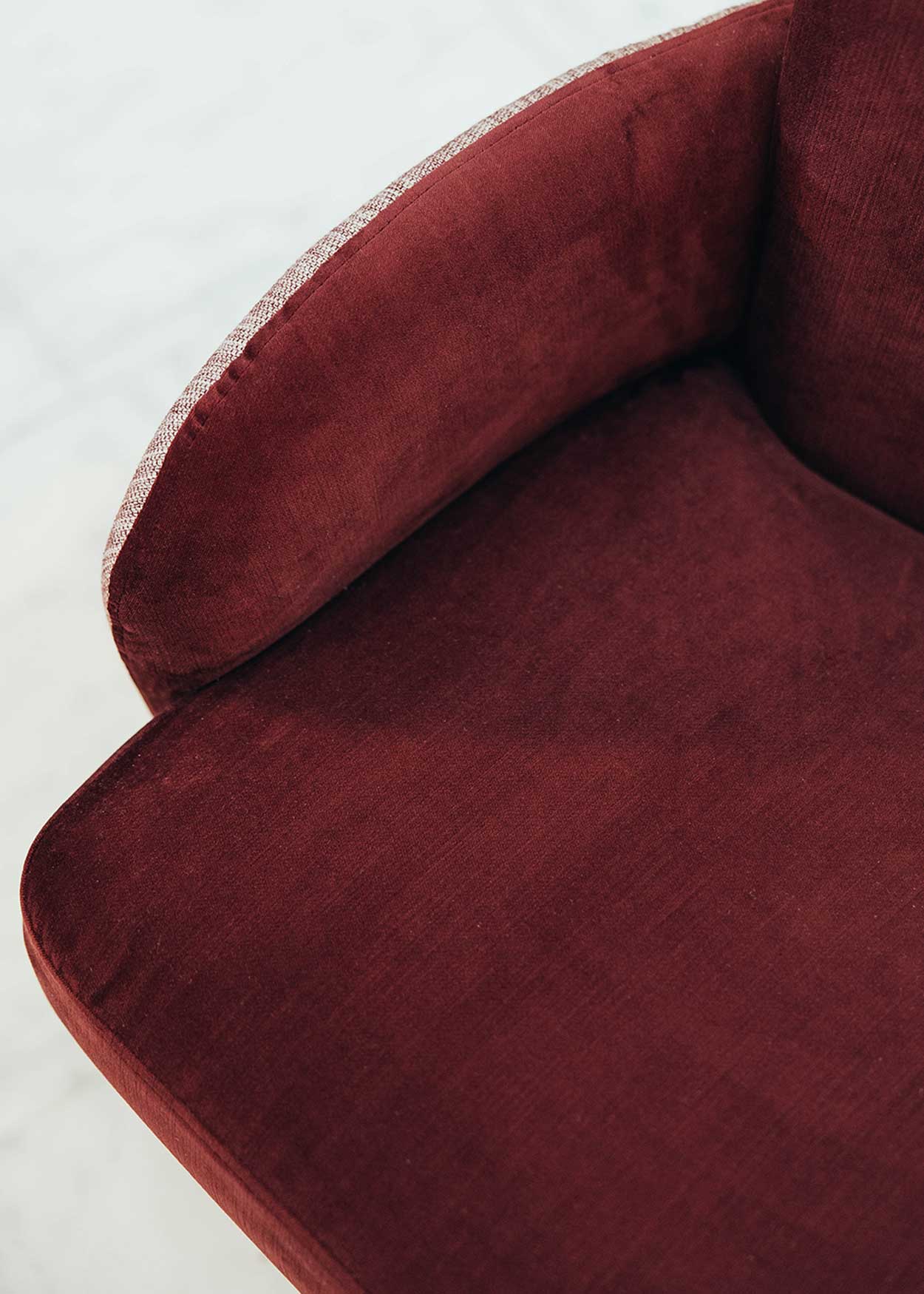 Butaca con estructura de madera tapizada en dos telas, un terciopelo color caldero y una tela jaspeada en tonos beige y caldero.