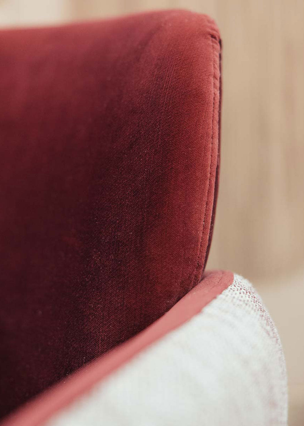 Butaca con estructura de madera tapizada en dos telas, un terciopelo color caldero y una tela jaspeada en tonos beige y caldero.