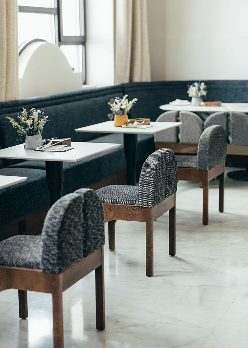 Silla de madera de haya con asiento tapizado en tela jaspeada en color blanco y negro.