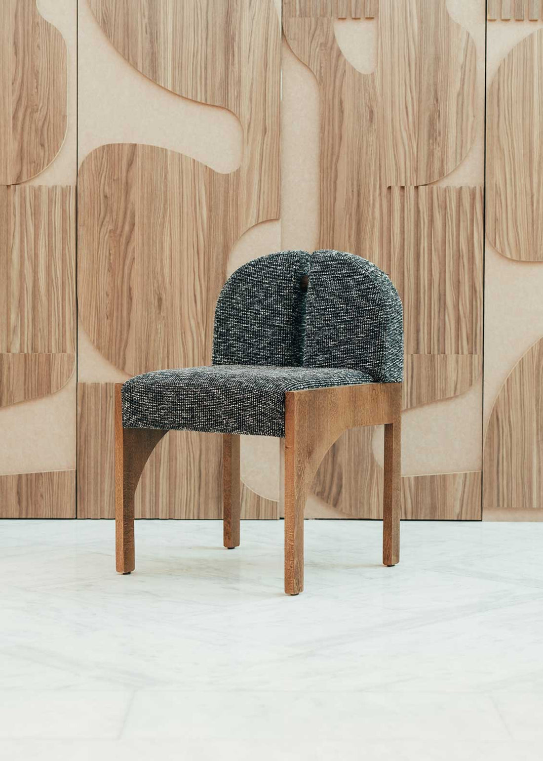 Silla de madera de haya con asiento tapizado en tela jaspeada en color blanco y negro.