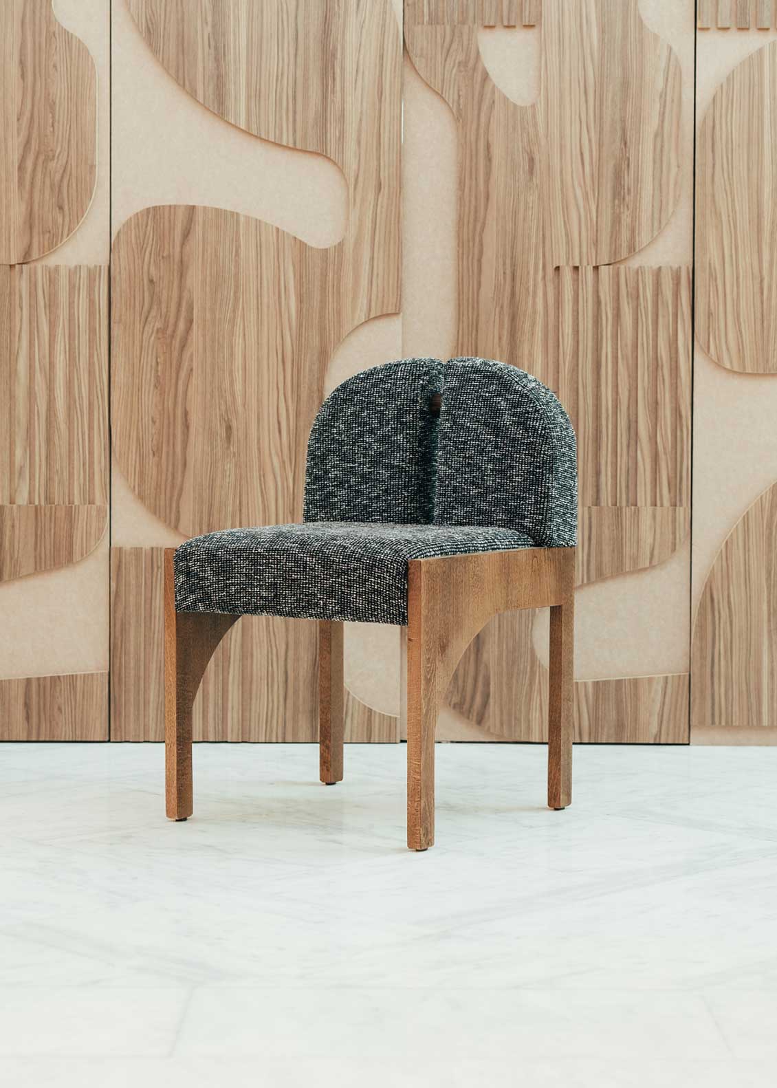 Silla de madera de haya con asiento tapizado en tela jaspeada en color blanco y negro.