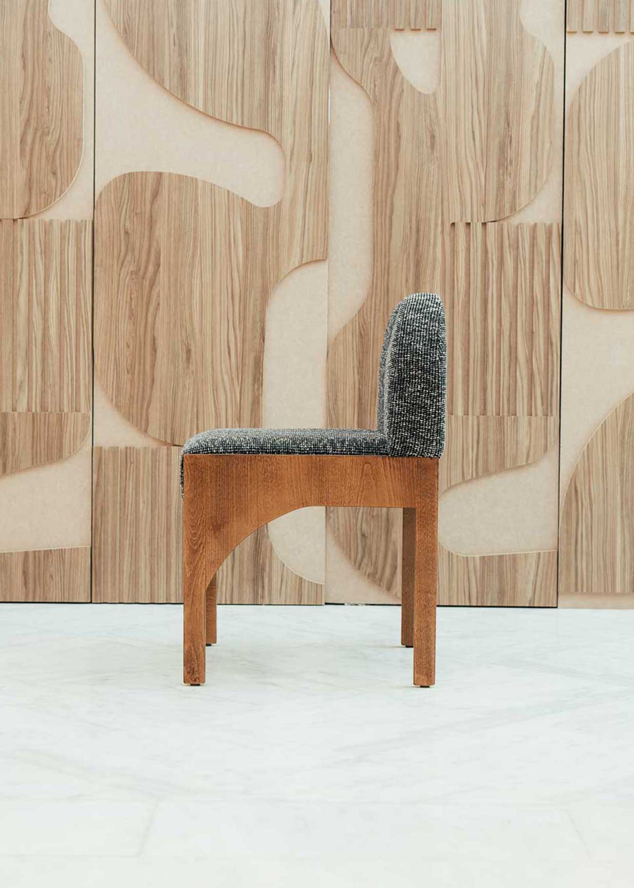 Silla de madera de haya con asiento tapizado en tela jaspeada en color blanco y negro.