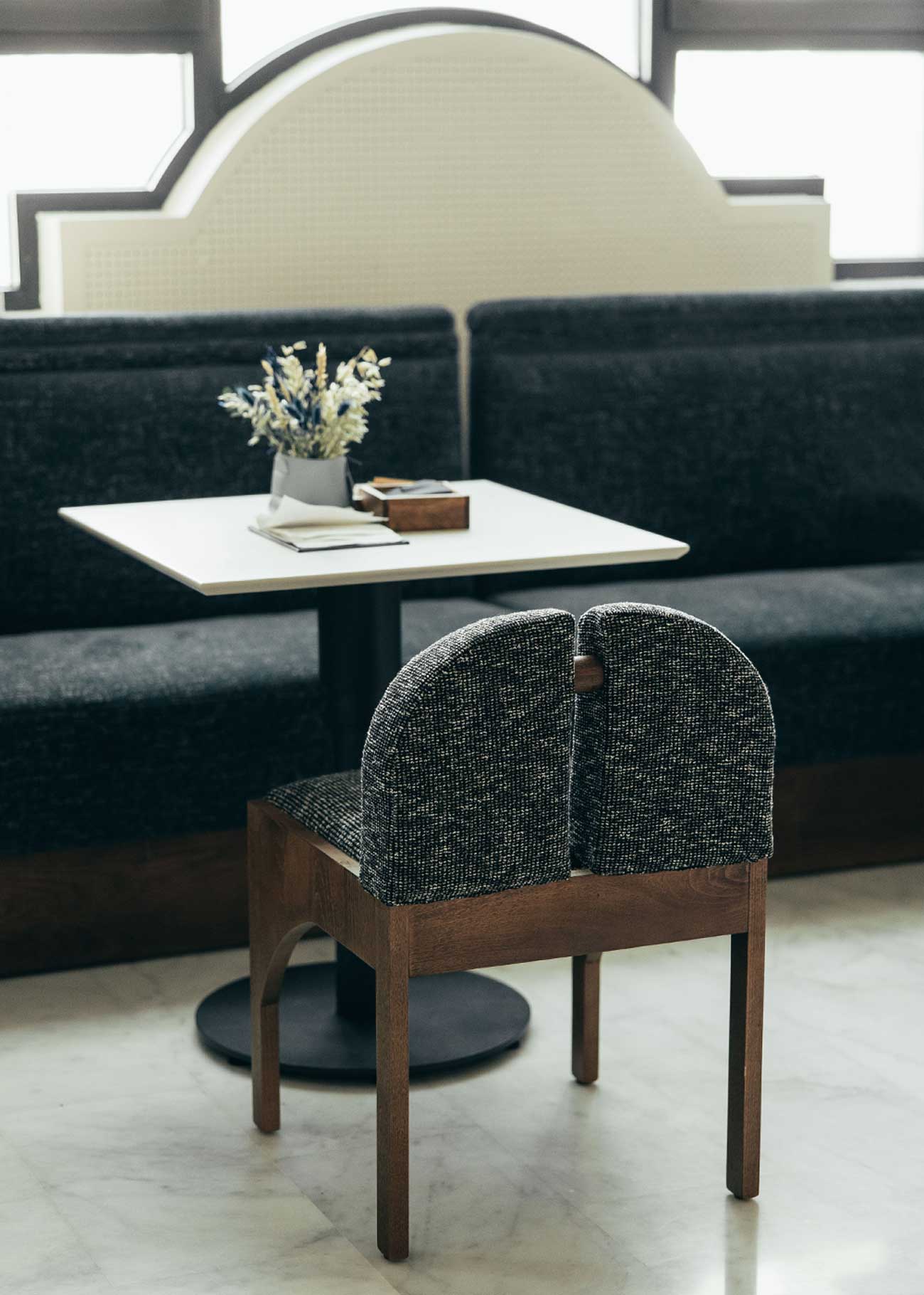 Silla de madera de haya con asiento tapizado en tela jaspeada en color blanco y negro.