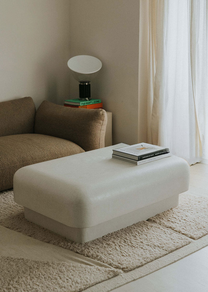 Mesa baja de centro con estructura de madera revestida de estuco en color crudo