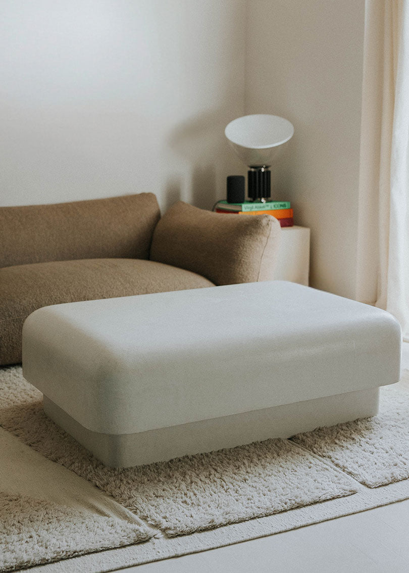 Mesa baja de centro con estructura de madera revestida de estuco en color crudo