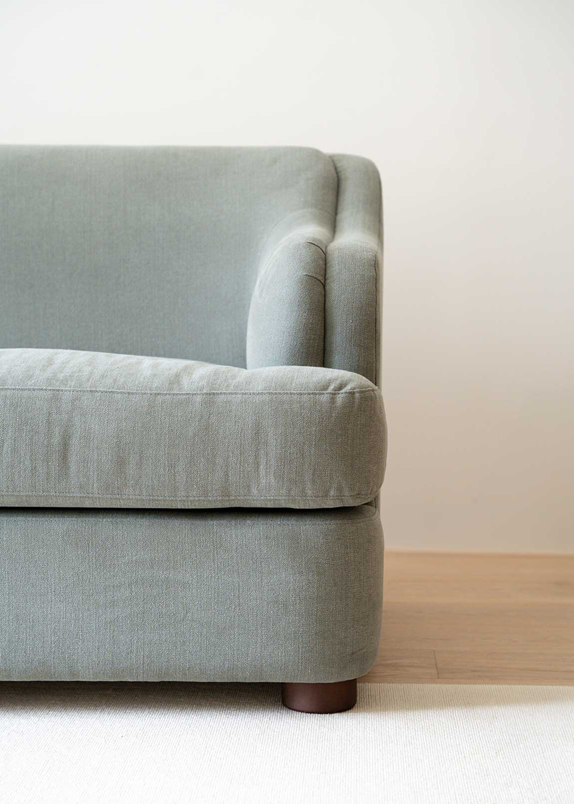 Sofá tapizado en tela gris de lino y algodón con estructura de madera de haya.
