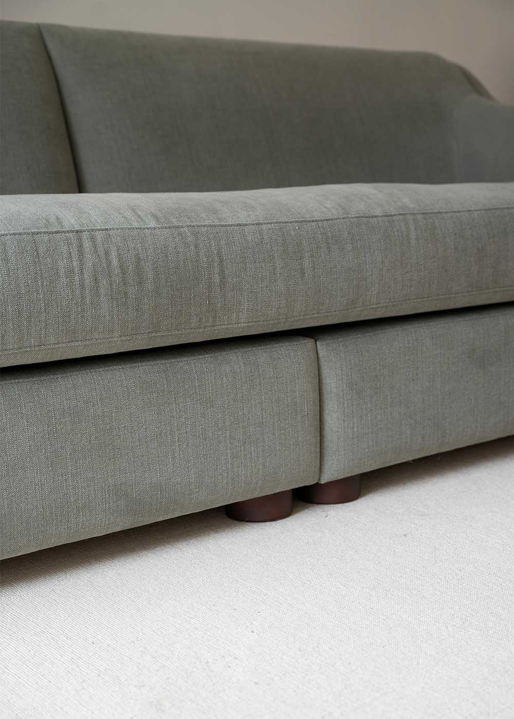 Sofá tapizado en tela gris de lino y algodón con estructura de madera de haya
