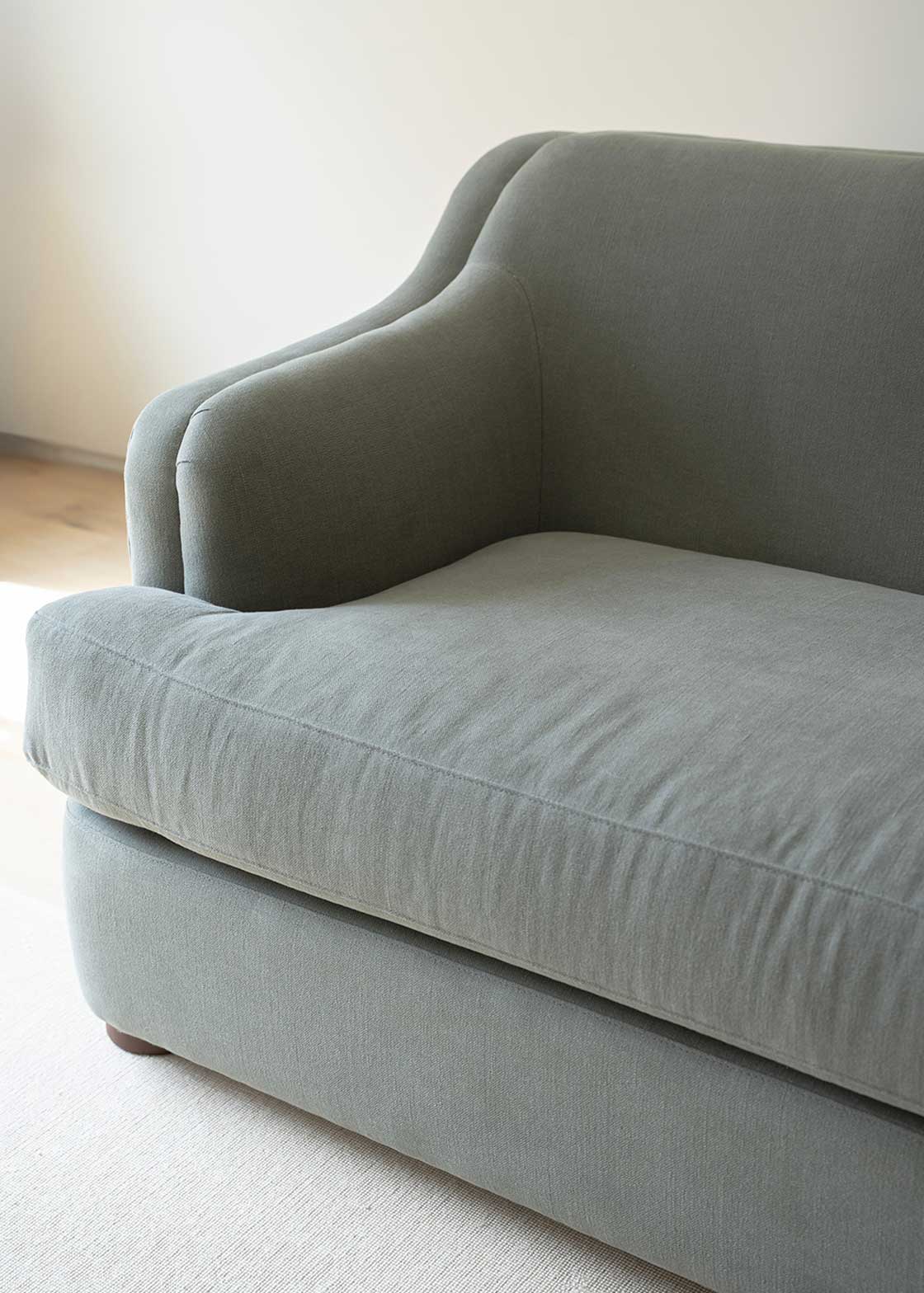Sofá tapizado en tela gris de lino y algodón con estructura de madera de haya