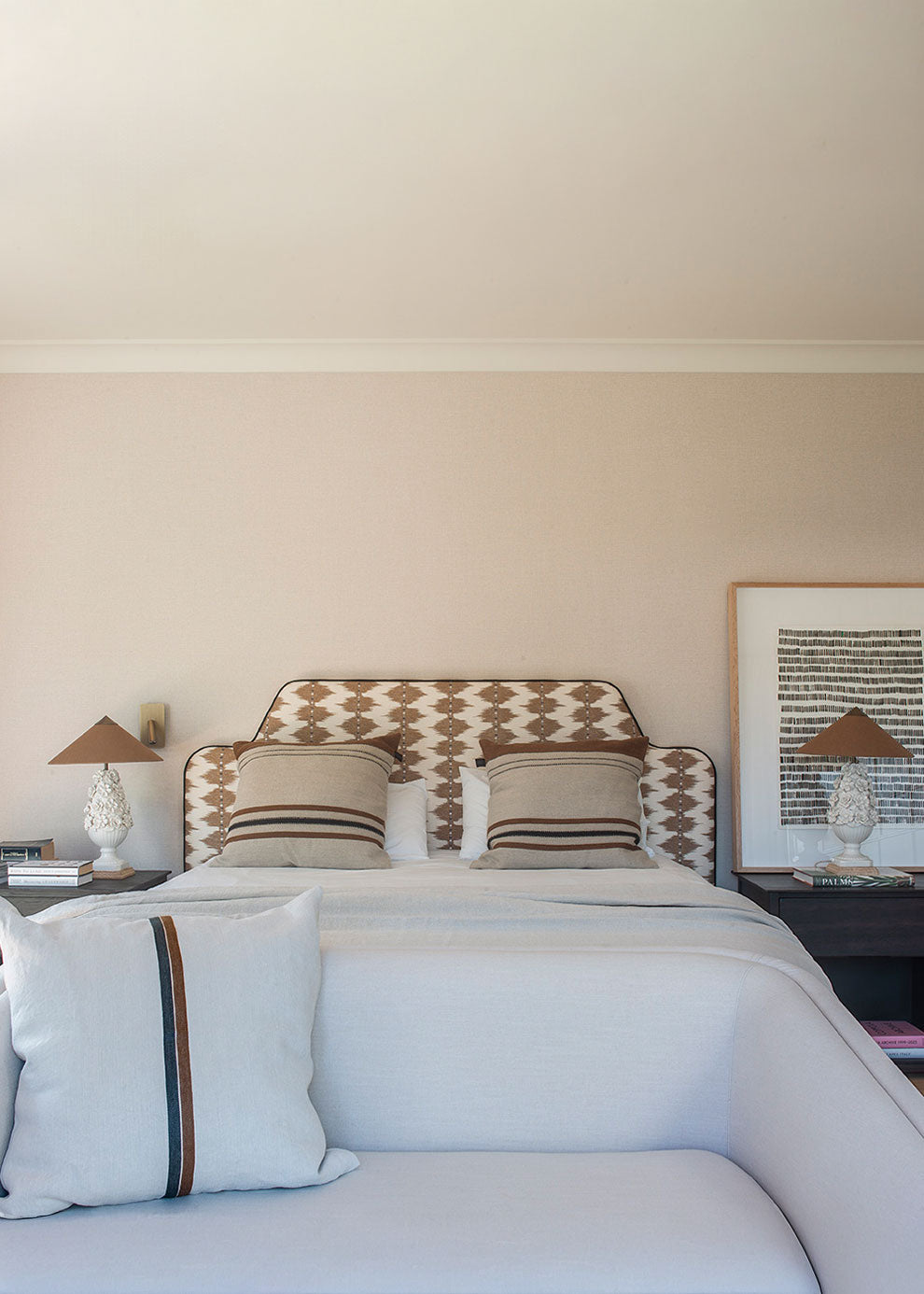 Cabecero tapizado con tela estampada en tonos ocres y crudos.