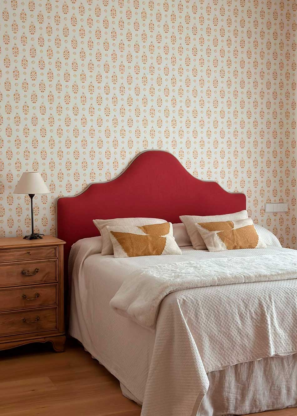 Cabecero tapizado en tela burdeos.