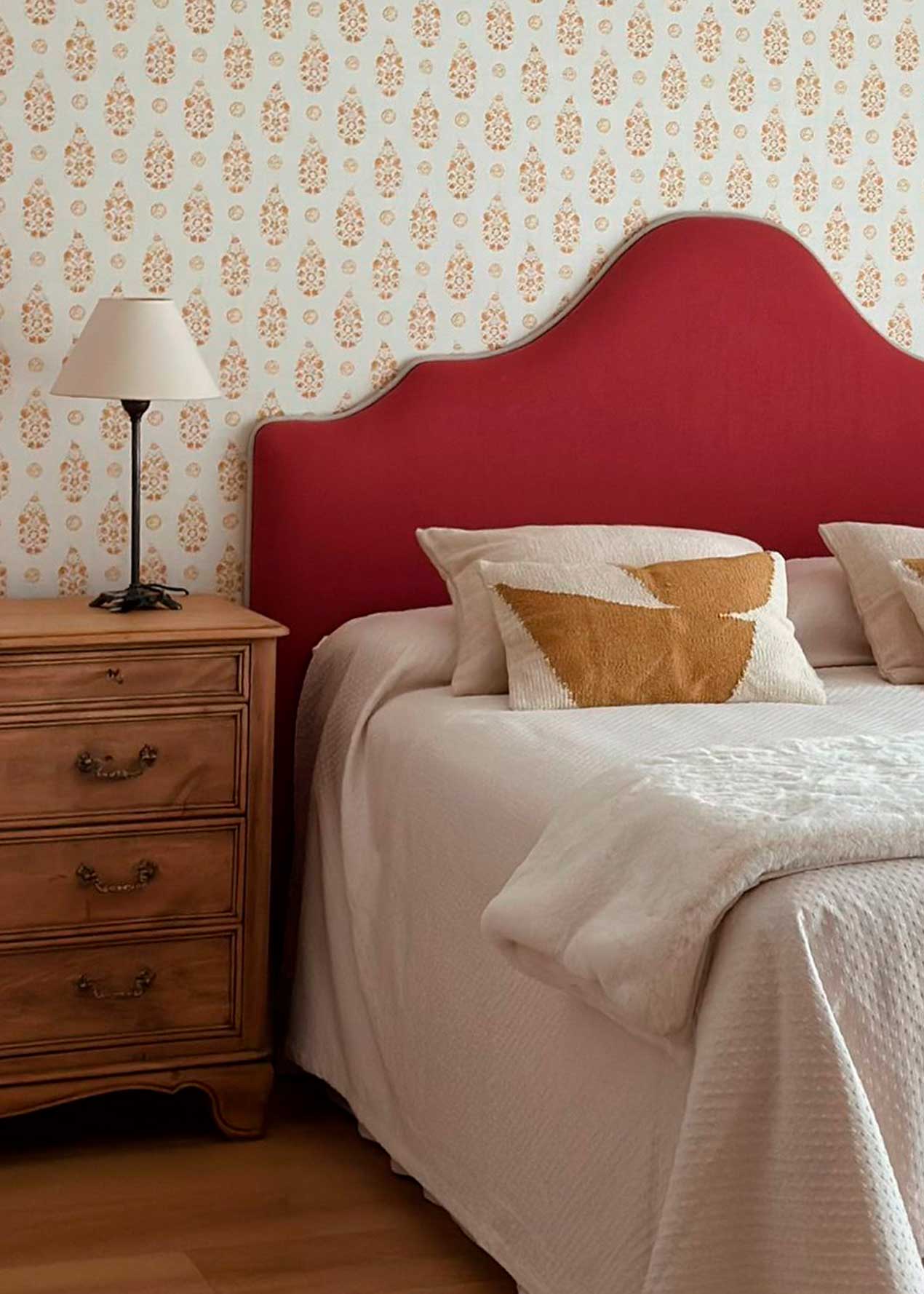 Cabecero tapizado en tela burdeos.