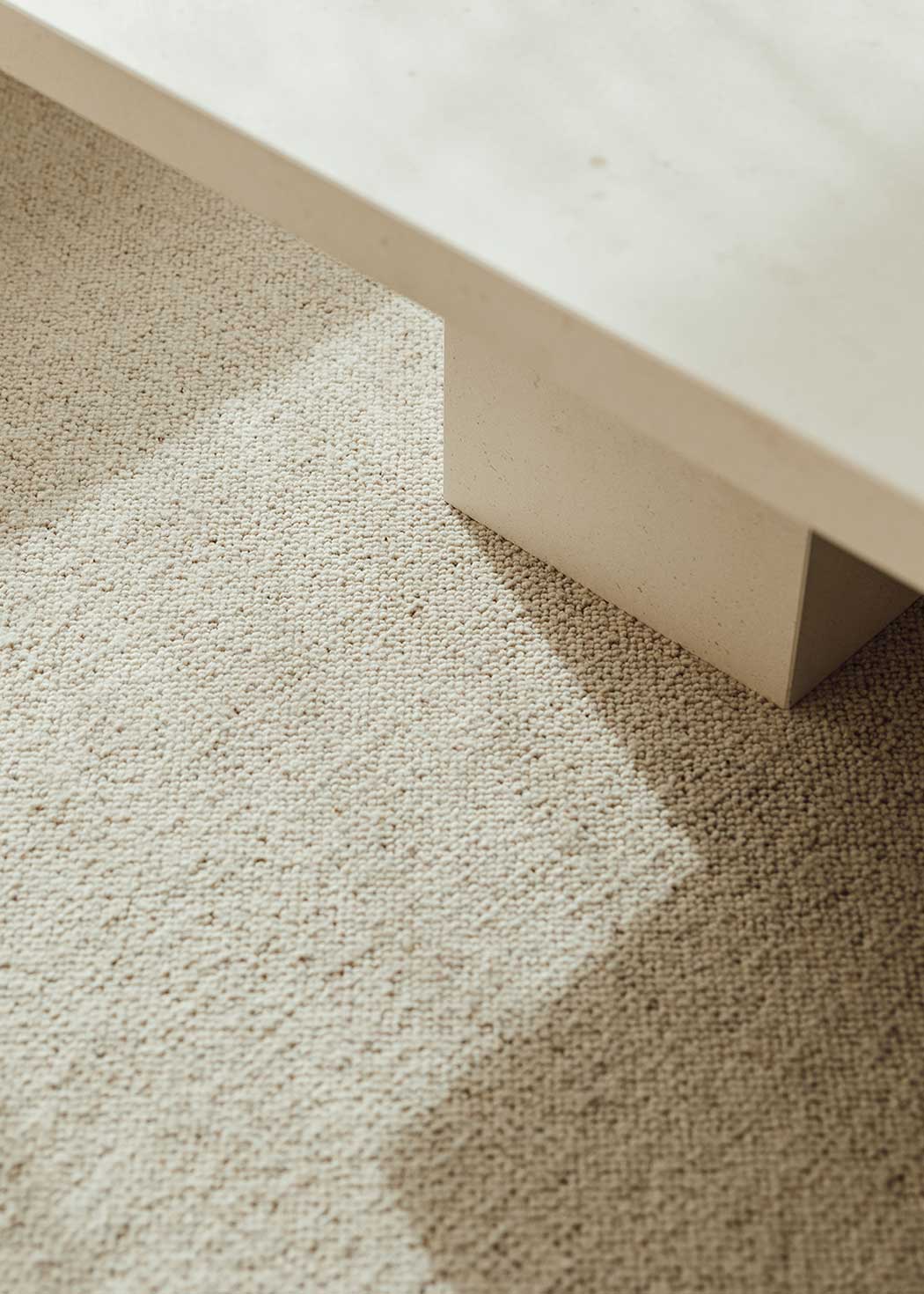 Mesa de centro fabricada en caliza con pie rectangular central.