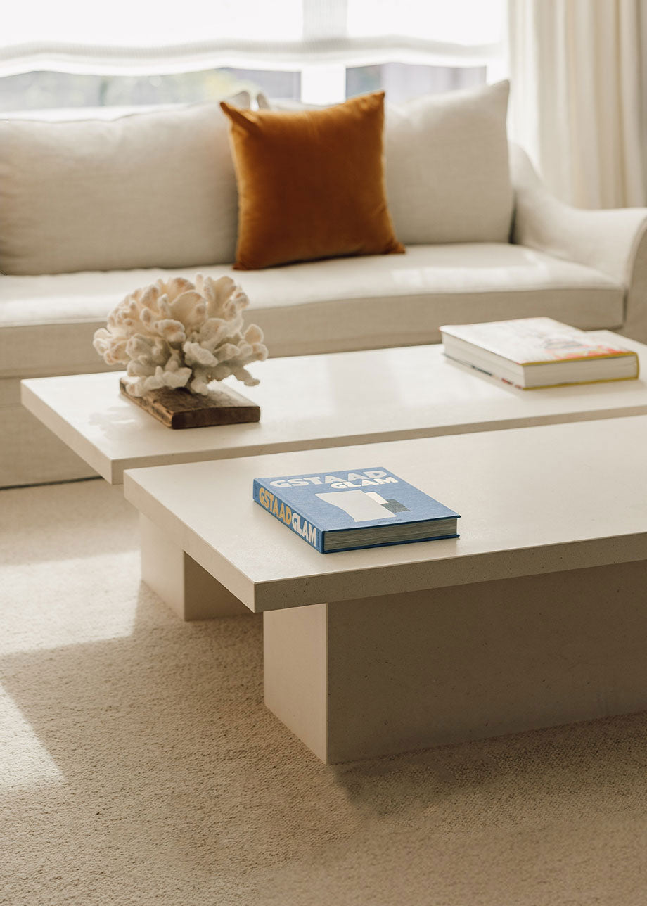 Mesa de centro fabricada en caliza con pie rectangular central.