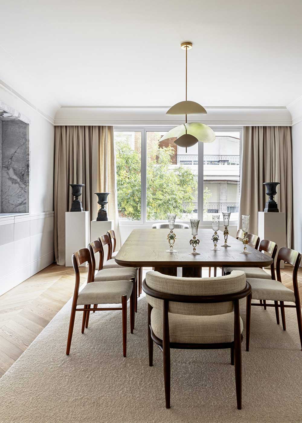 Mesa de comedor rectangular formada por sobre y patas perpendiculares en madera de roble.