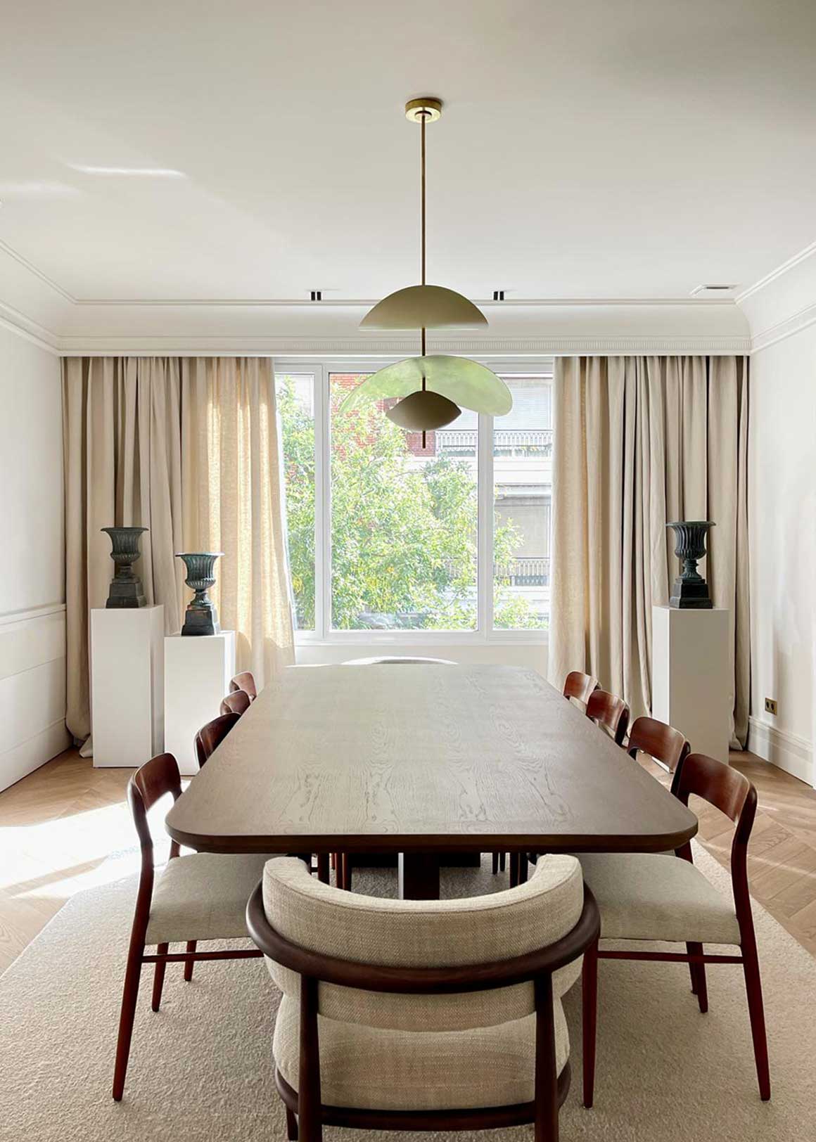 Mesa de comedor rectangular formada por sobre y patas perpendiculares en madera de roble.