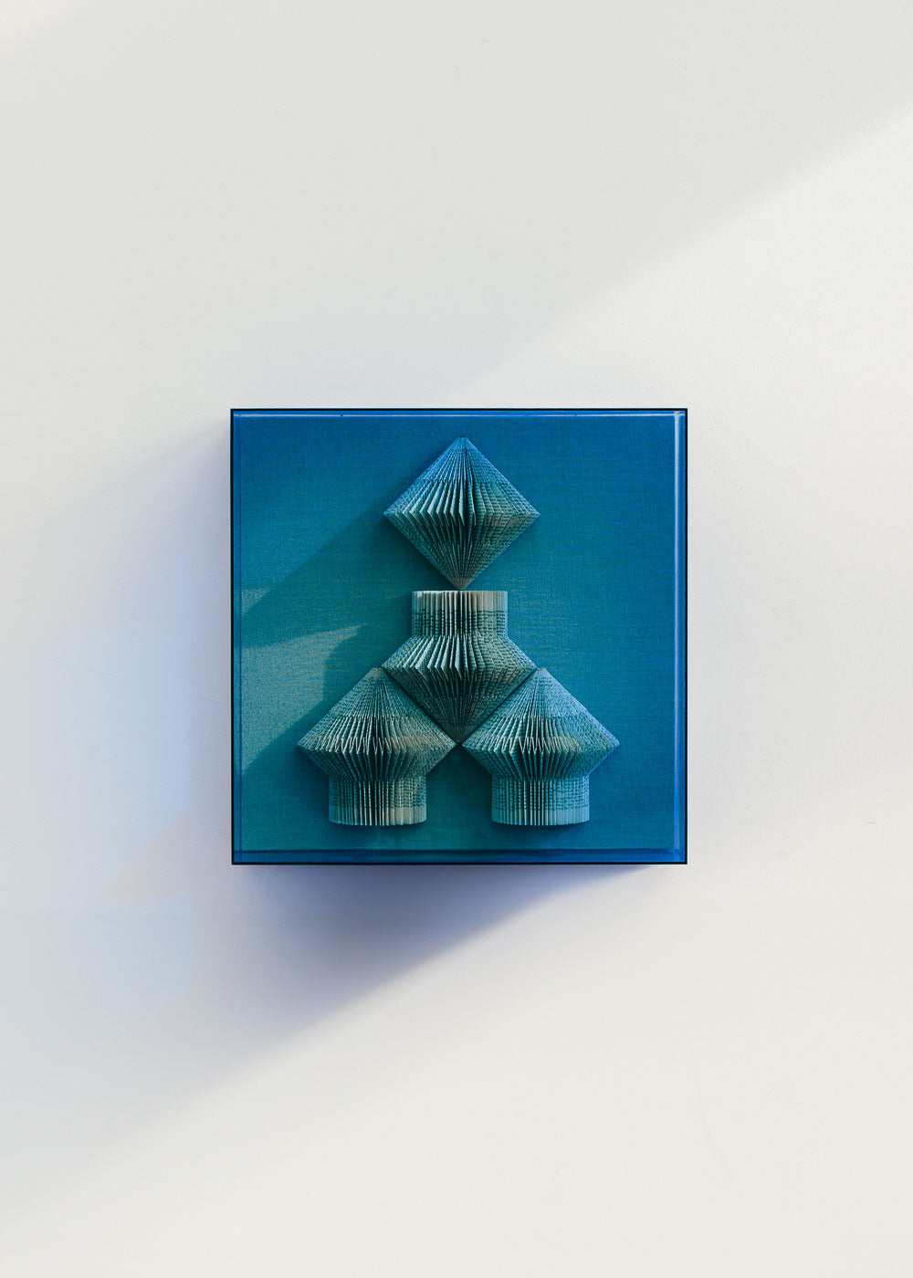 Escultura de pared forrada en lino con caja de metacrilato azul