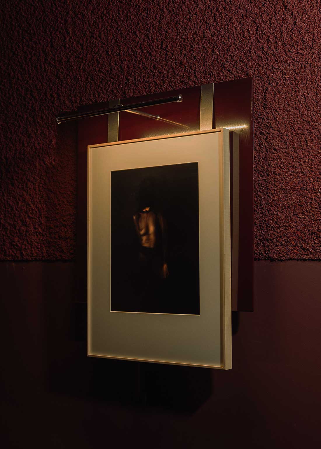 Portacuadros de acero lacado con pletinas de acero cepillado con aplique sobre cuadro integrado.