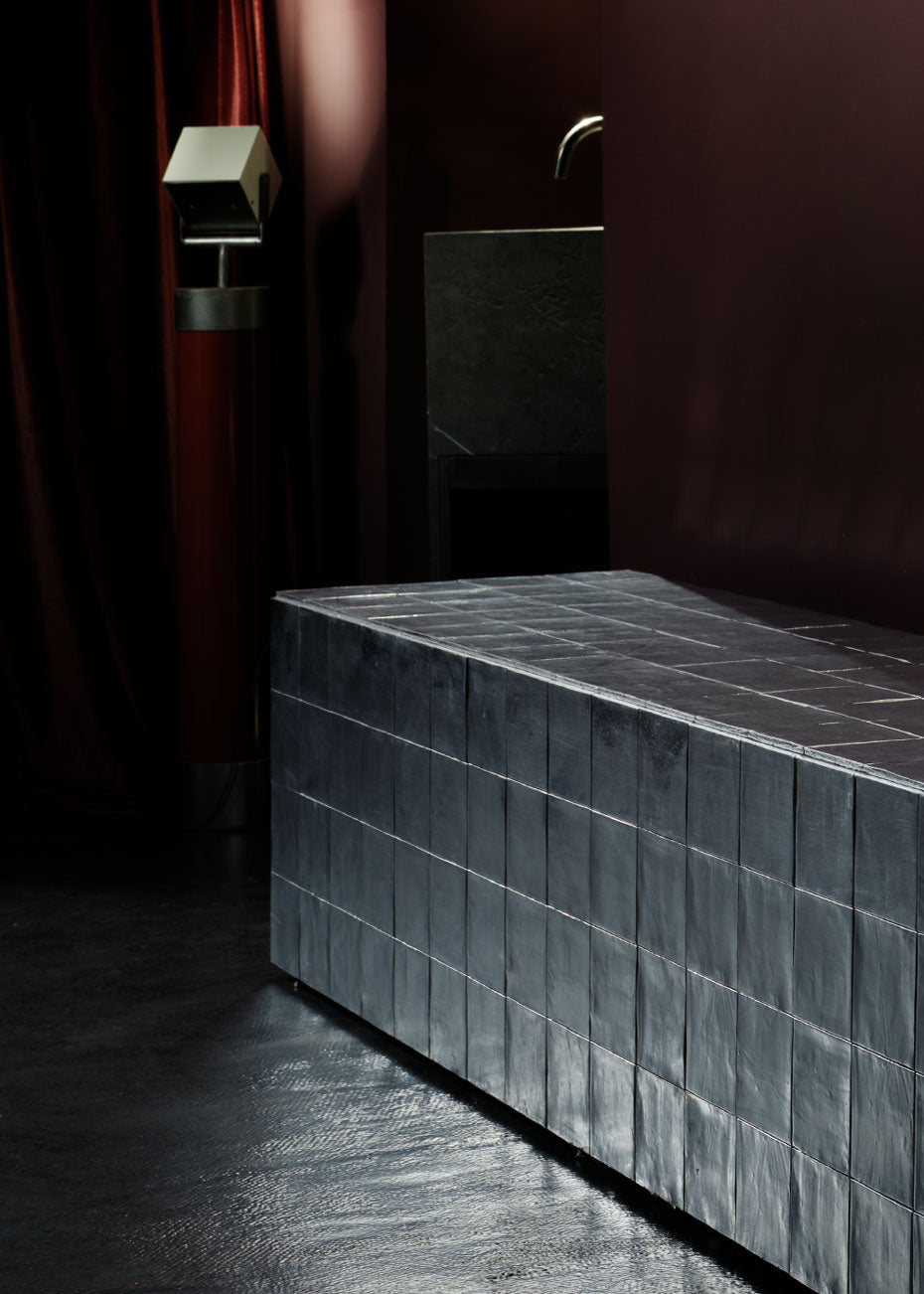 Foco orientable de pie de estilo industrial con soporte de acero lacado en rojo. Está diseñado para ir anclado al suelo.