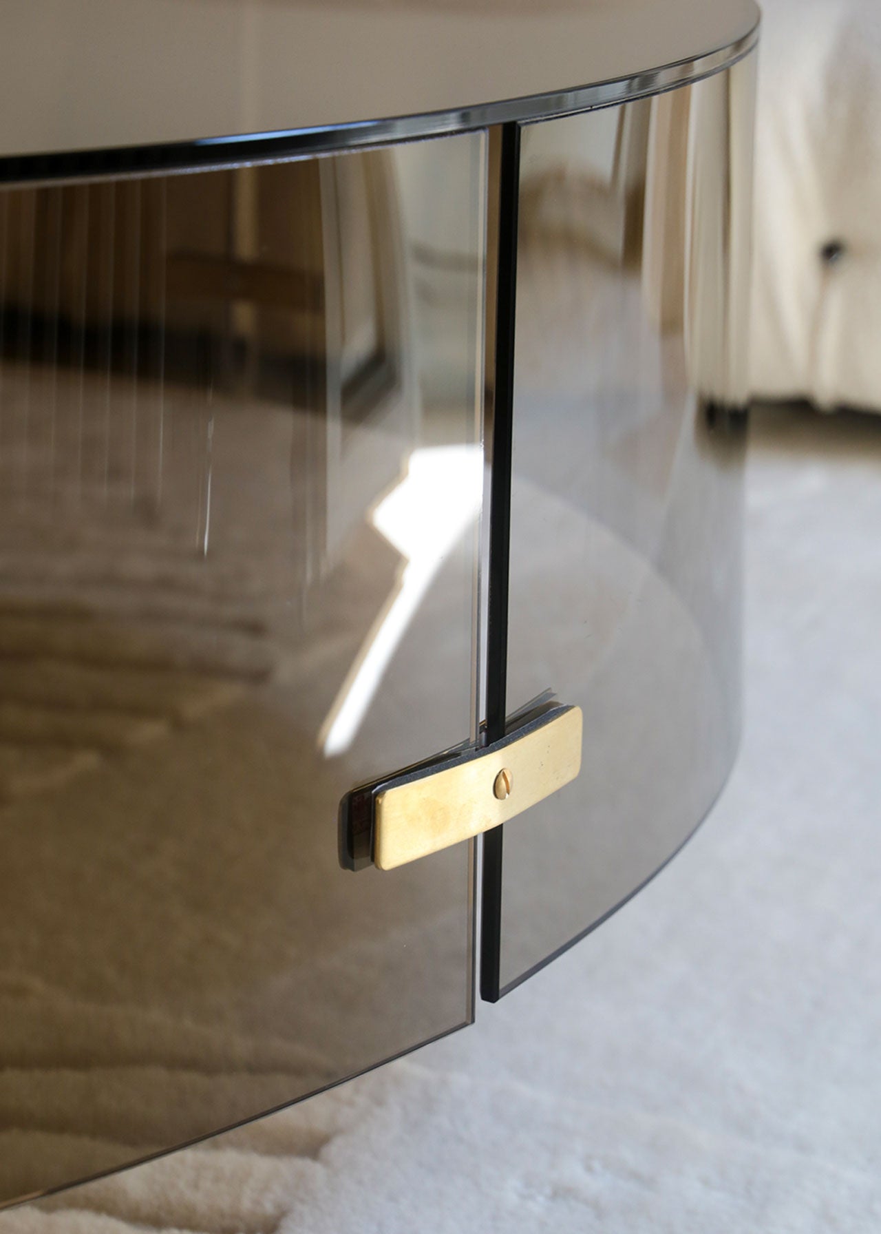 Mesa baja de centro de vidrio y detalles de latón. El sobre es de vidrio ahumado bronce.