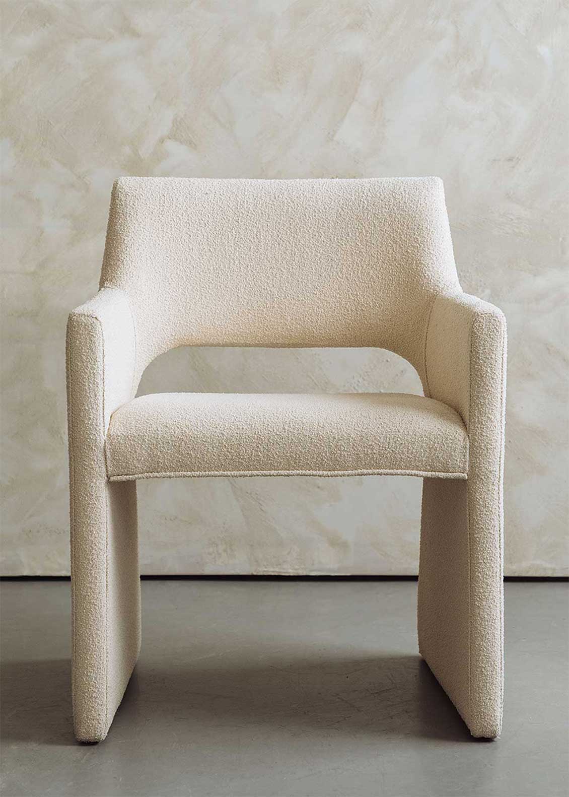 Butaca tapizada en tela beige.
