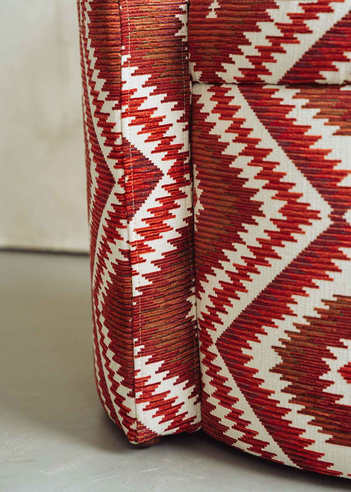 Butaca tapizada con tela de estampado geométrico rojo.