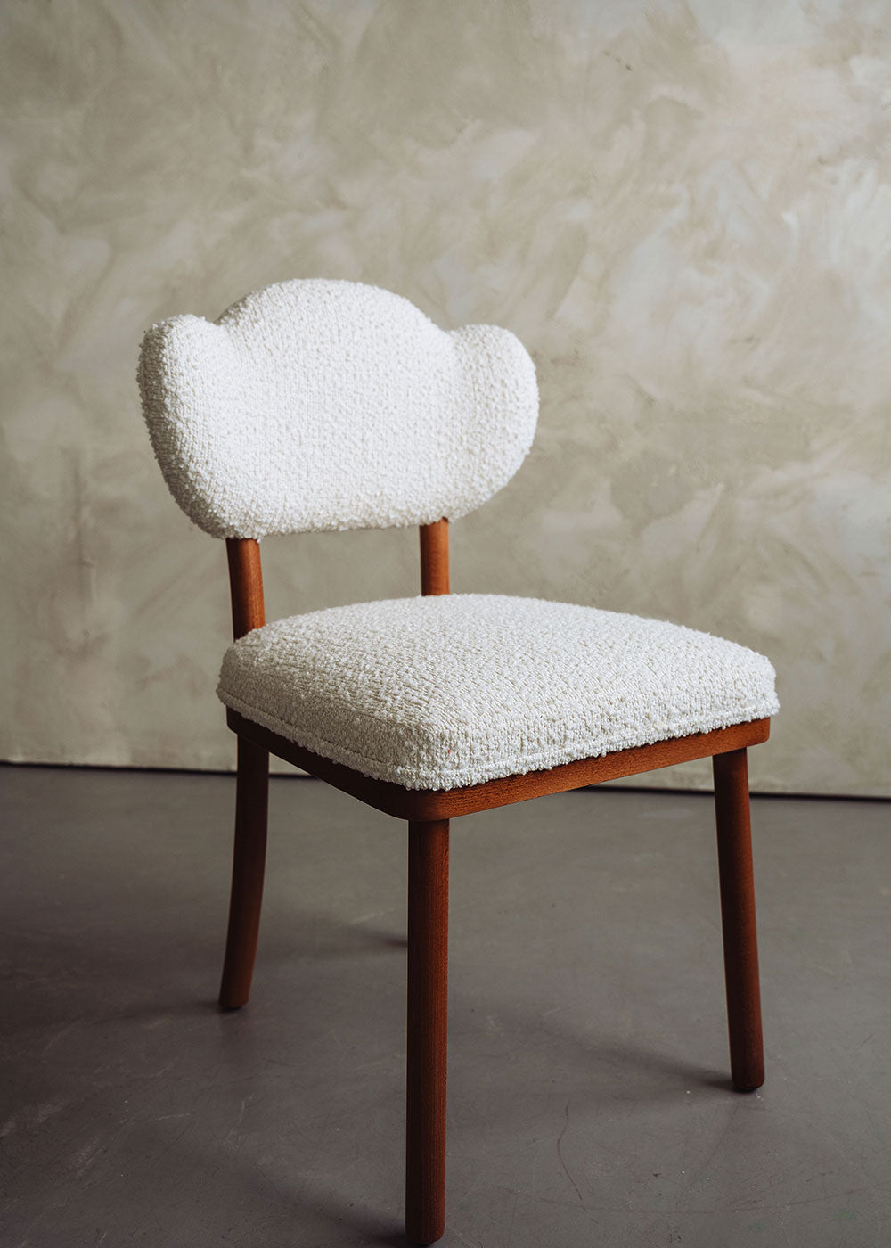 Silla de madera de haya tapizada en bouclé blanco.