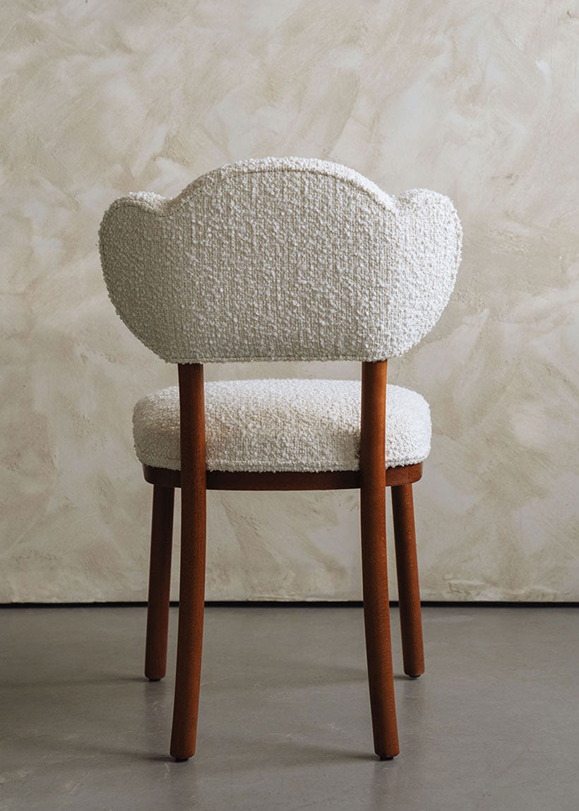 Silla de madera de haya tapizada en bouclé blanco.