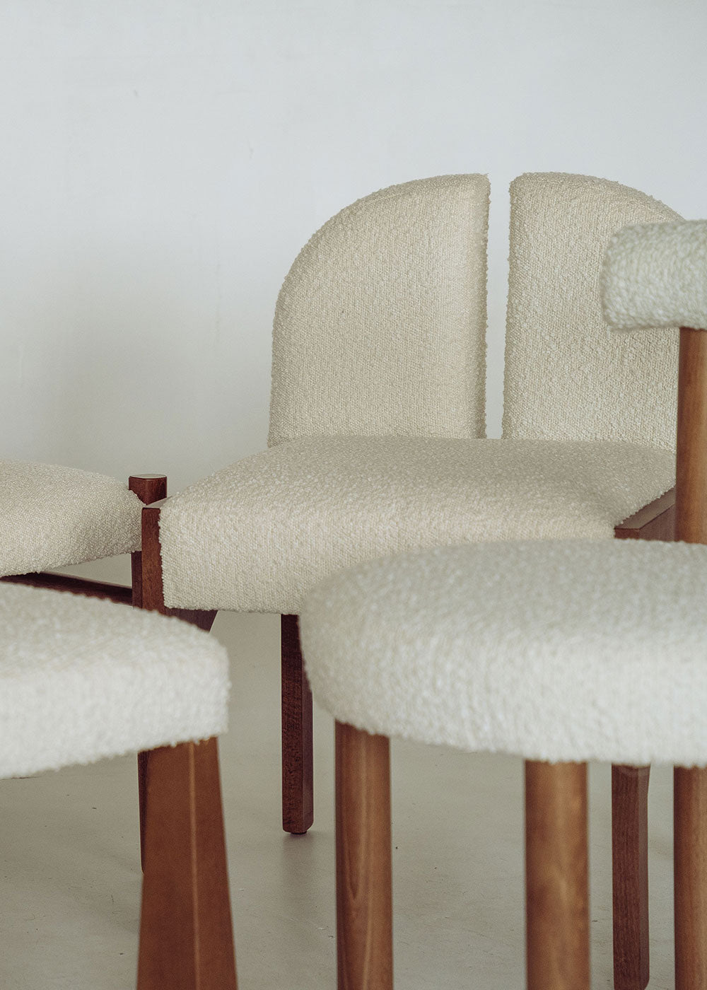 Silla de madera de haya tapizada en bouclé blanco.