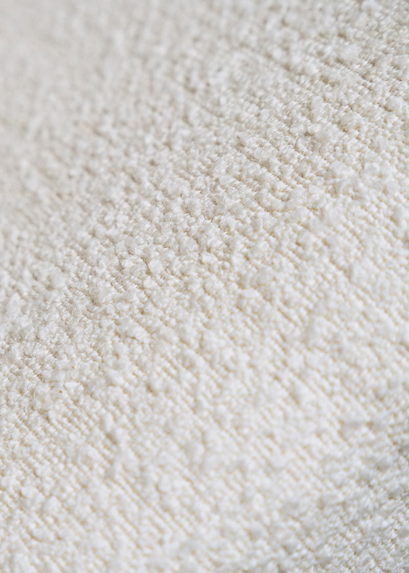 Silla de madera de haya tapizada en bouclé blanco.