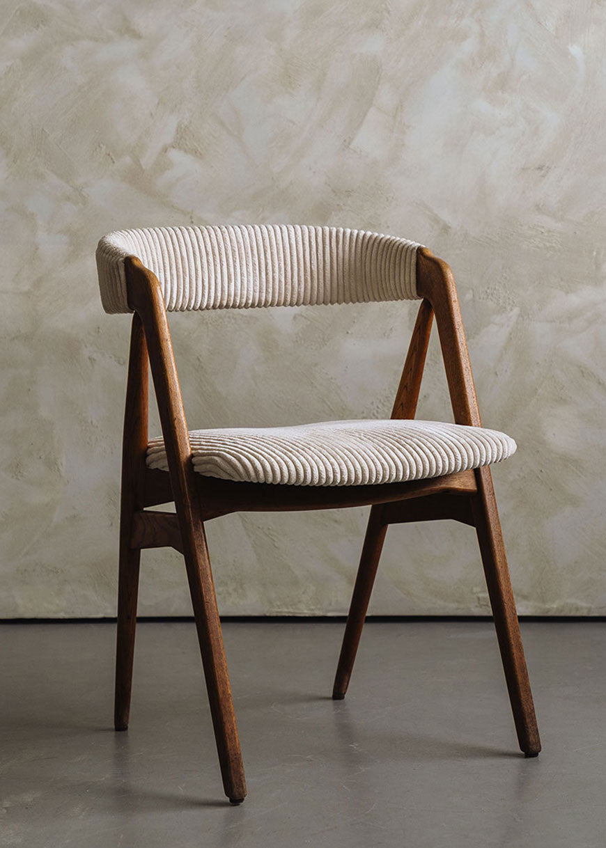 Silla de madera de haya tapizada en pana beige.