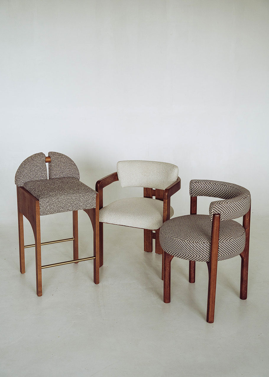 Silla de madera de haya con reposabrazos tapizada en terciopelo beige.