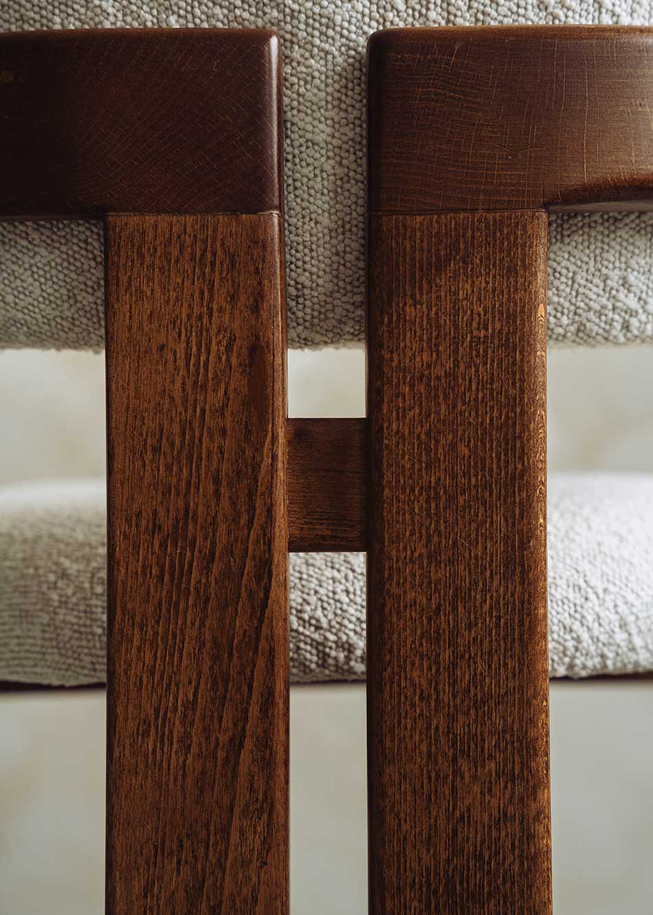 Silla de madera de haya con reposabrazos tapizada en terciopelo beige.