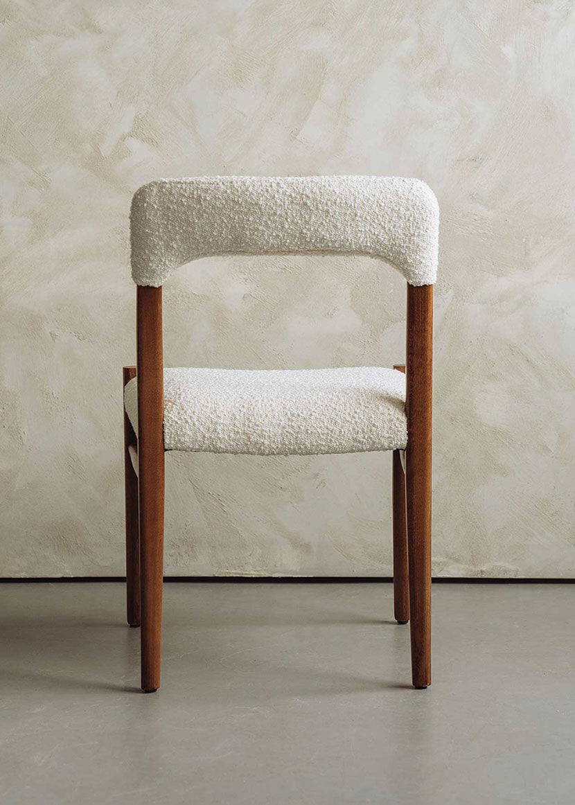 Silla de madera de haya tapizada en bouclé blanco.