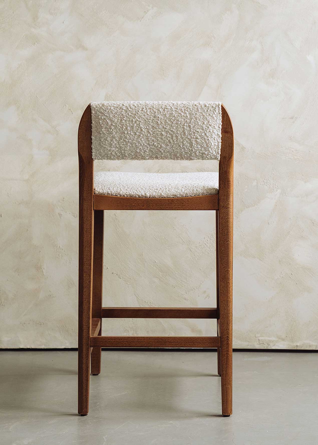 Taburete tapizado en pana beige con estructura de madera de haya. Un taburete alto con respaldo y reposapiés incorporado.