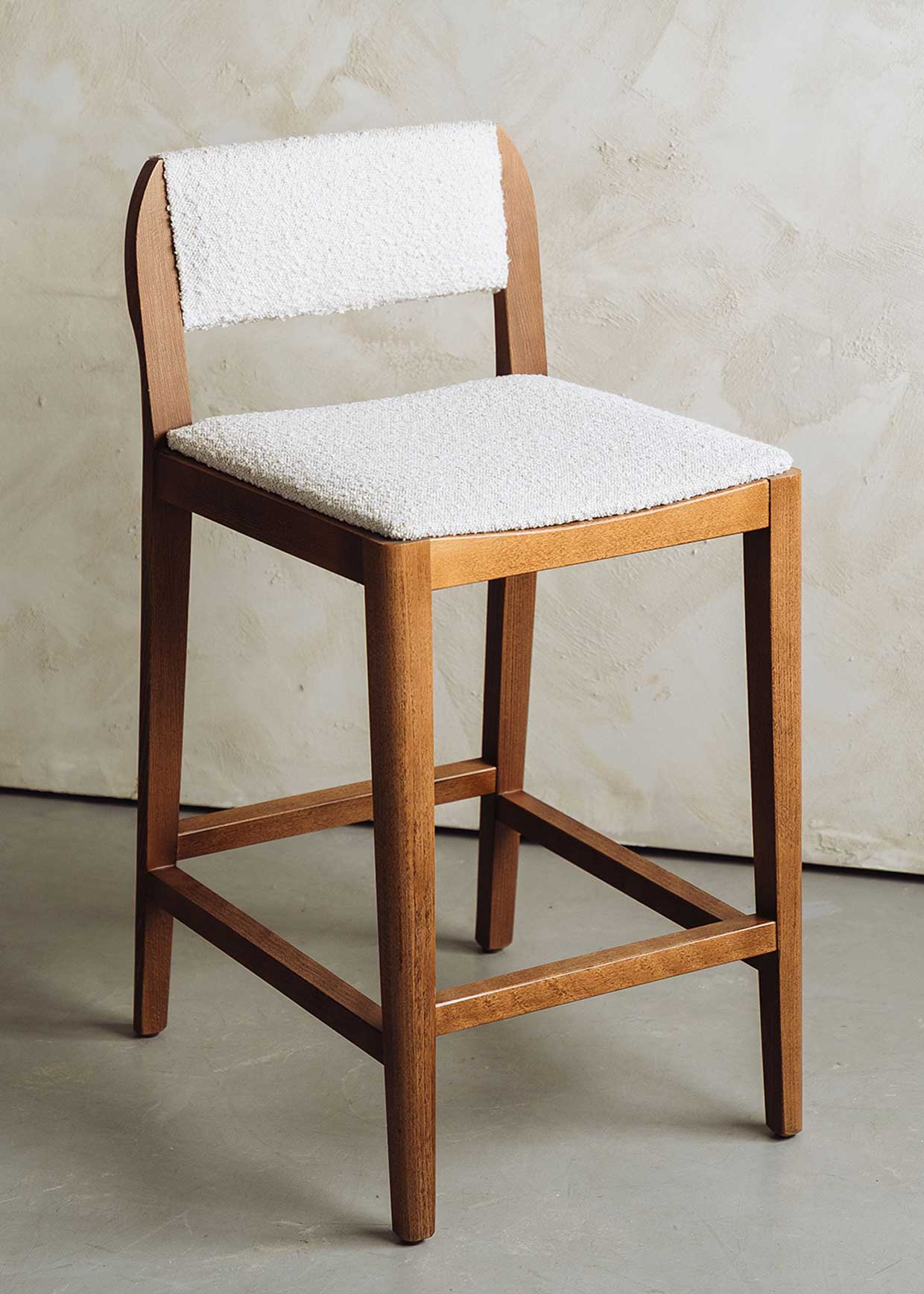 Taburete tapizado en pana beige con estructura de madera de haya. Un taburete alto con respaldo y reposapiés incorporado.