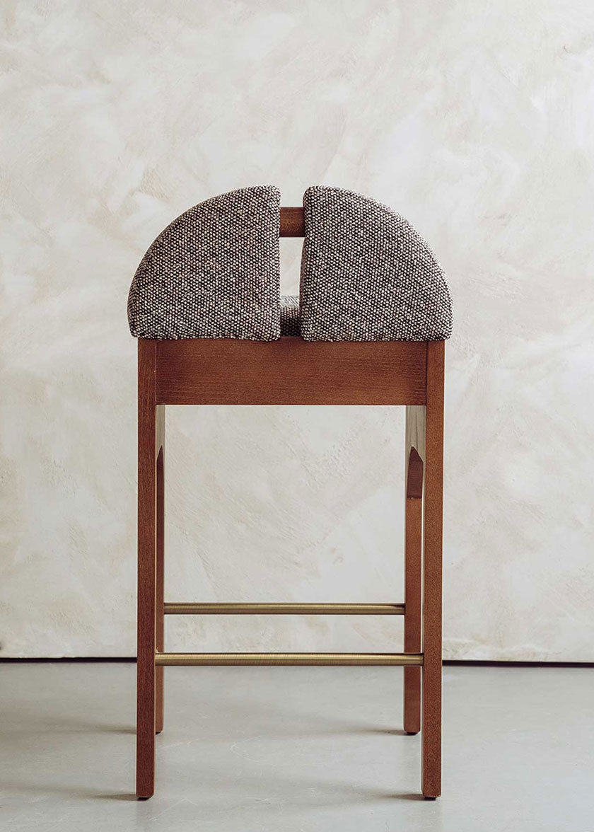 Taburete tapizado en tela jaspeada blanca y negra con estructura de madera de haya. Un taburete alto con respaldo y reposapiés incorporado.