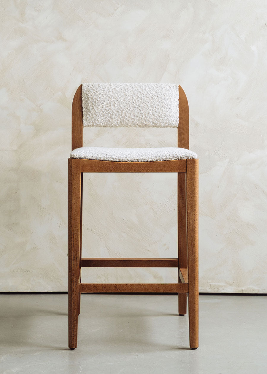 Taburete tapizado en pana beige con estructura de madera de haya. Un taburete alto con respaldo y reposapiés incorporado.