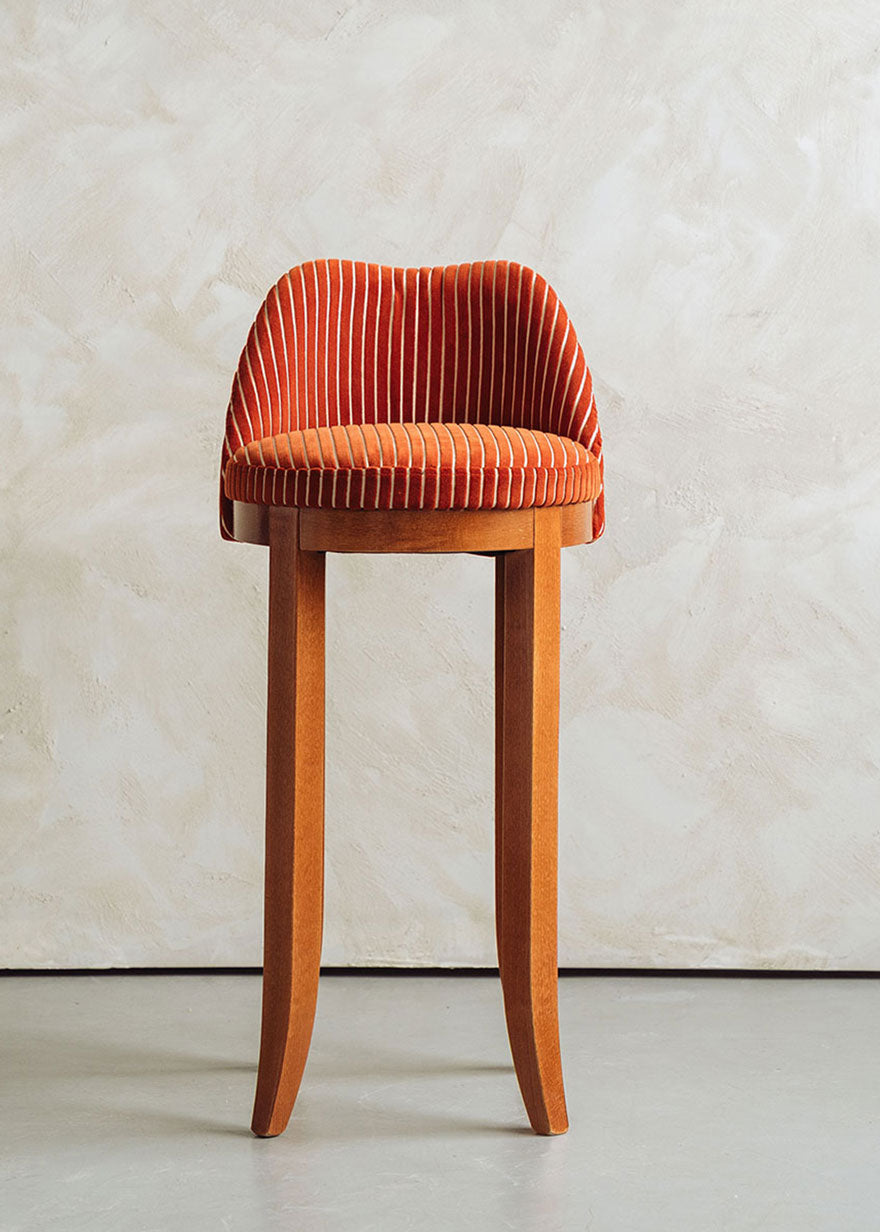 Taburete con respaldo tapizado en terciopelo caldera rayado con estructura de madera de haya.