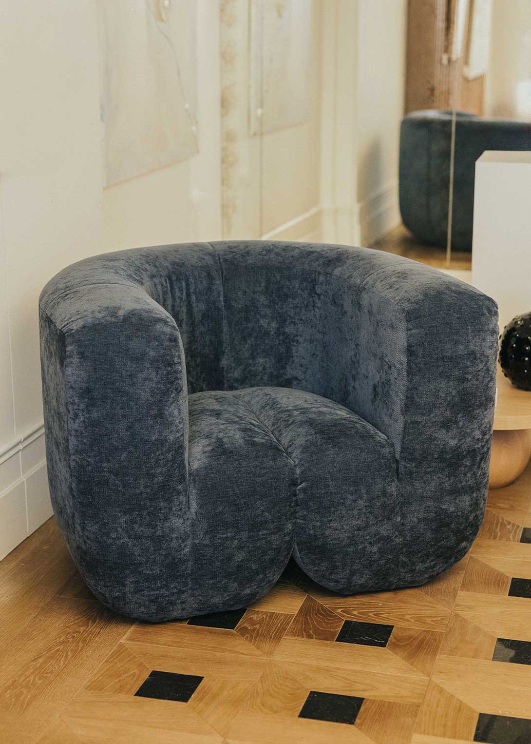 Sillón tapizado con tela de chenilla azul.