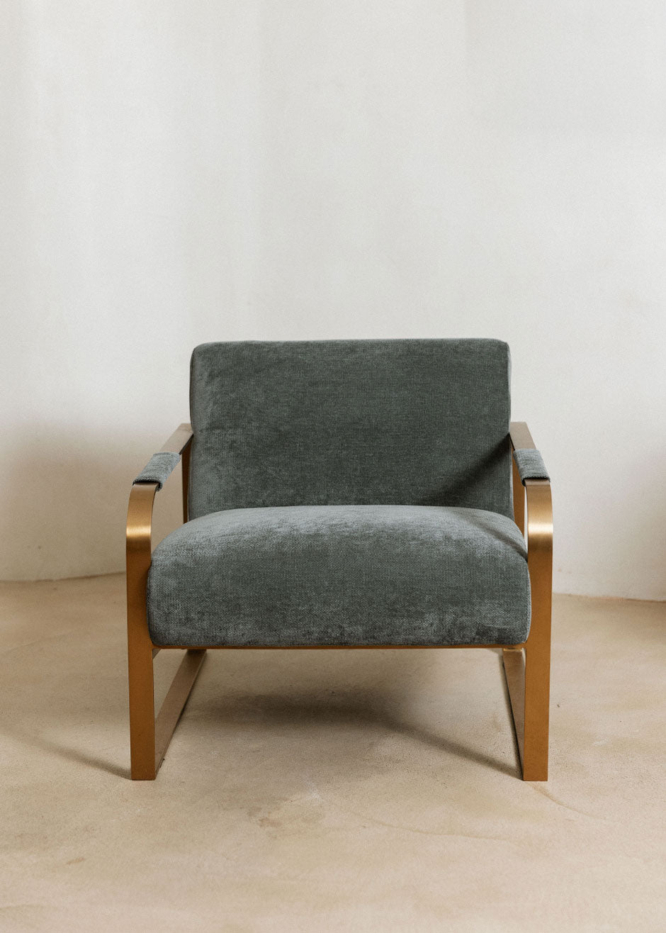 Butaca con reposabrazos tapizado con tela de chenilla azul.