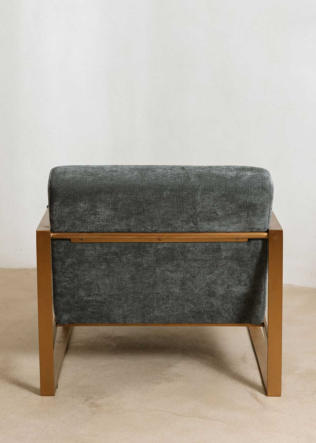 Butaca con reposabrazos tapizado con tela de chenilla azul.