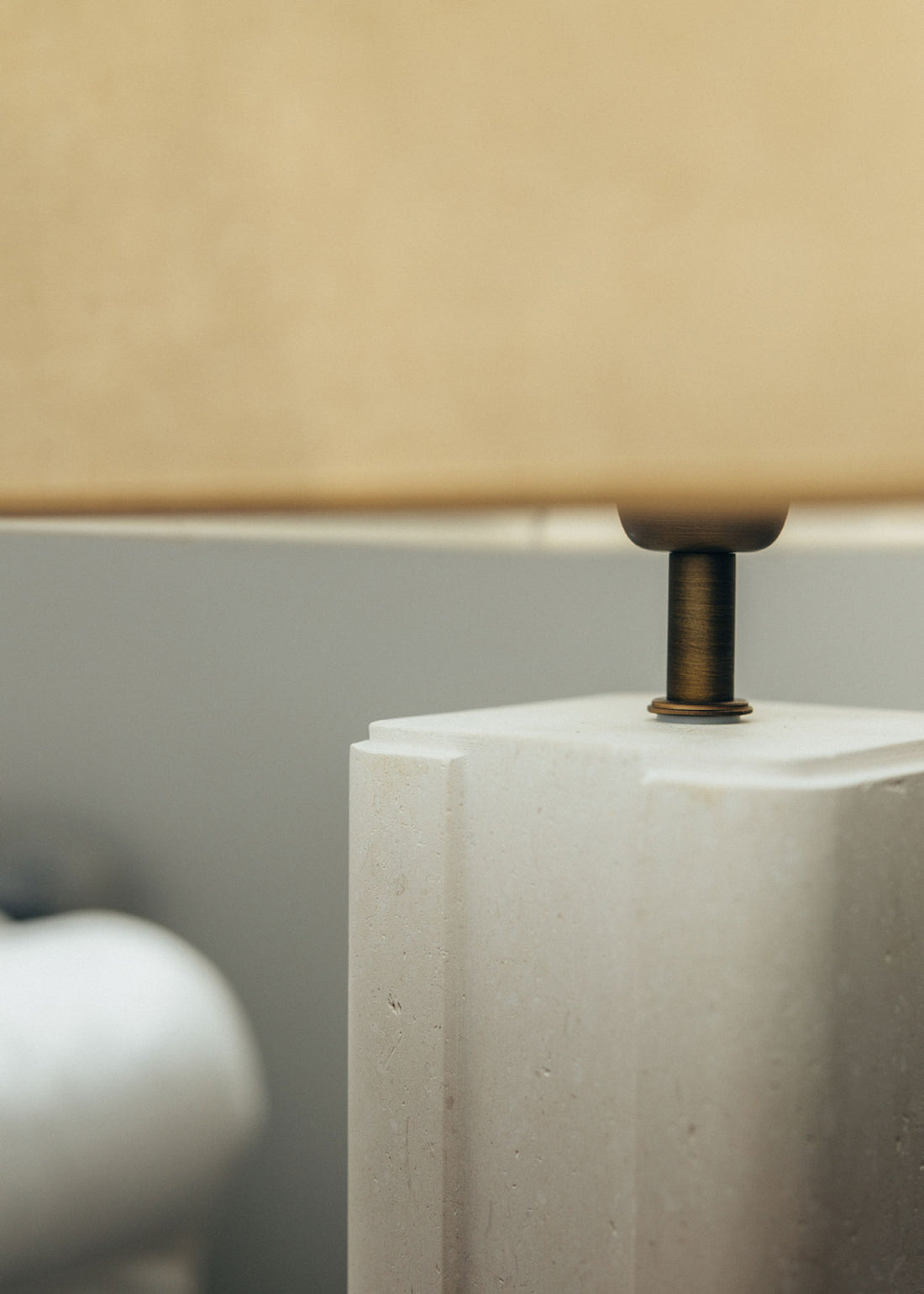 Lámpara de mesa con base escultórica realizada en un único bloque de piedra caliza tallado.