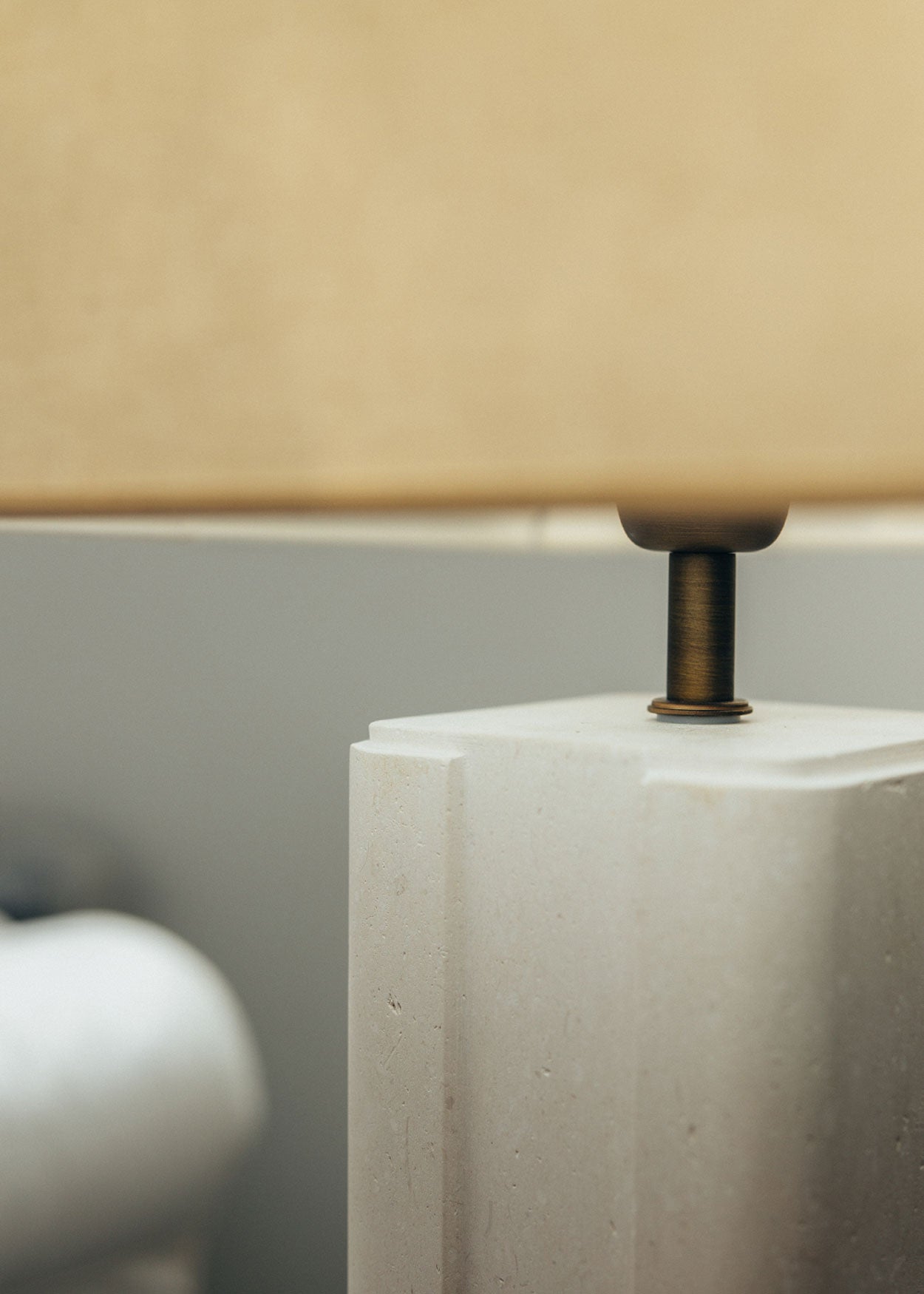 Lámpara de mesa con base escultórica realizada en un único bloque de piedra caliza tallado.