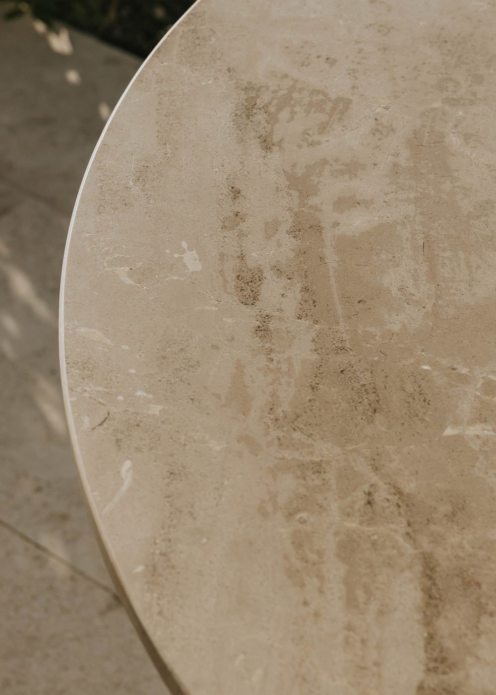 Mesa de exterior circular con estructura de hierro y caliza