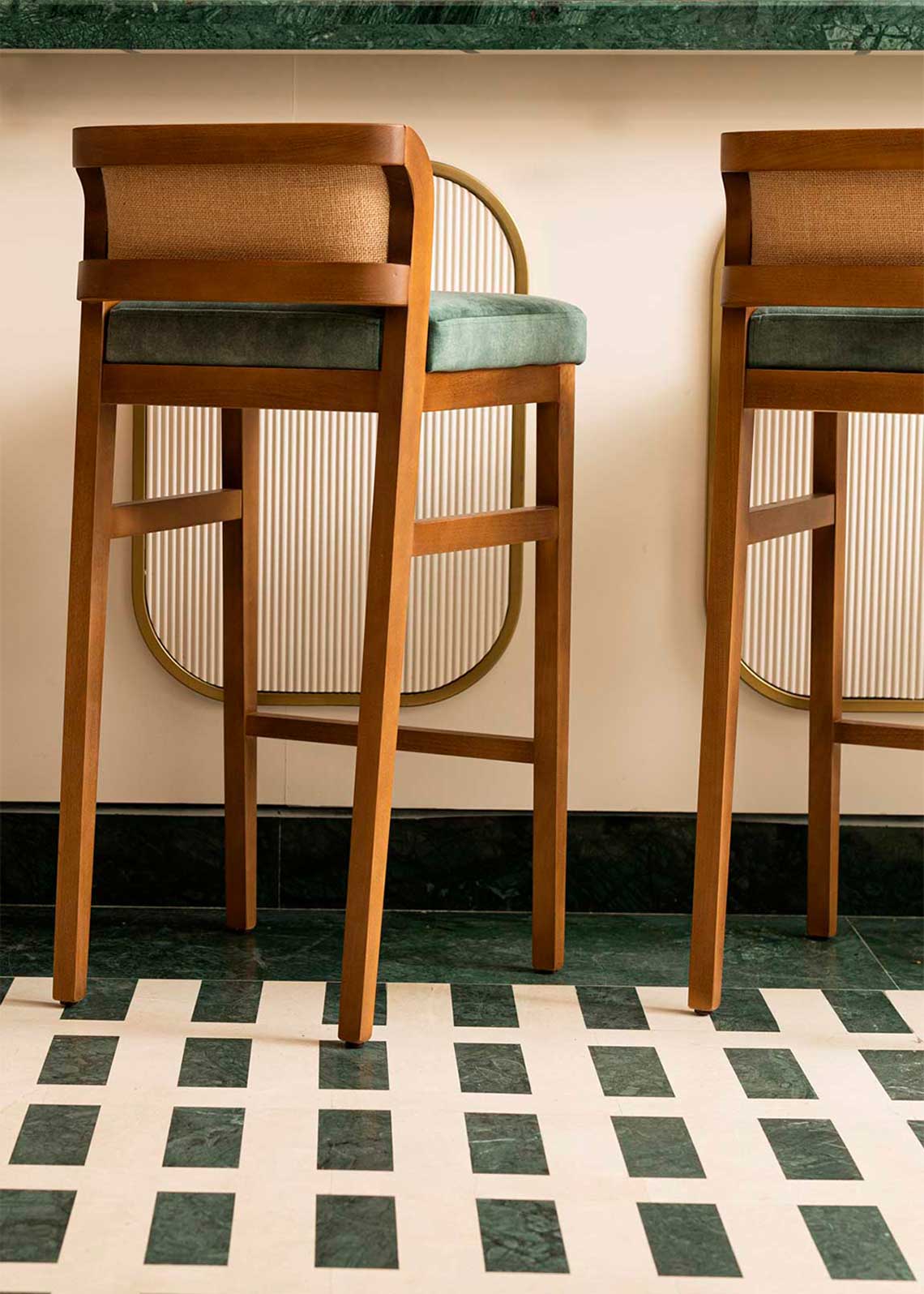 Taburete con estructura de madera de haya tapizado en terciopelo verde con respaldo de tela de yute
